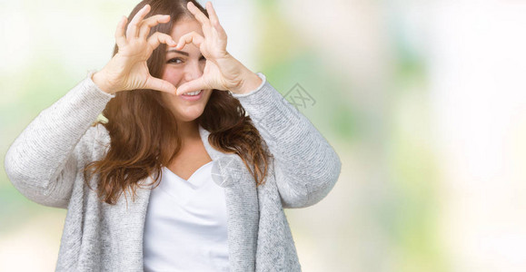 身穿冬装背景孤立的漂亮大码年轻女用手和指微笑着透图片