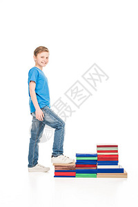 可爱的小可爱男孩踩在书本上微笑着图片