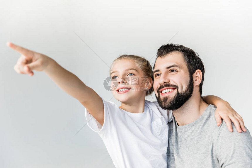 美丽的快乐的父亲和女儿用白的手指着她而去图片