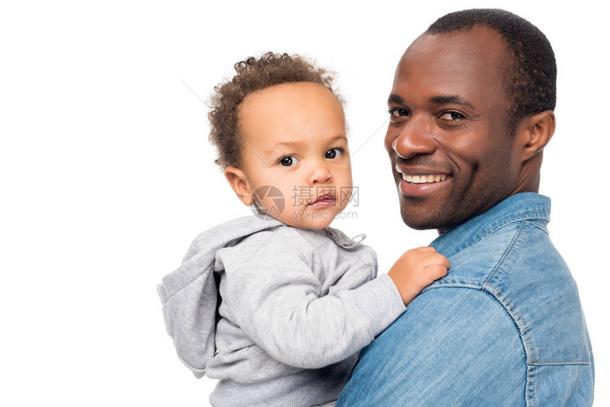快乐的非洲美国父亲和小儿子看着在白色上被图片