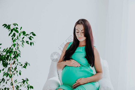 分娩前的孕妇坐在白色沙发上1图片