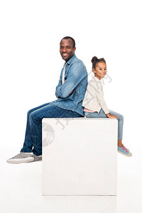欢乐的非洲父亲和可爱的小女儿坐在一起笑着微笑着在镜头中被图片
