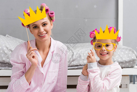 带着玩具化装王冠的睡衣中母亲和图片