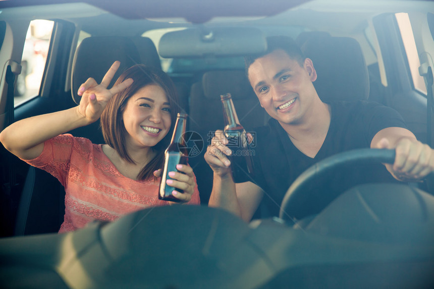 不负责任的年轻成年人在开车时玩乐喝啤酒图片