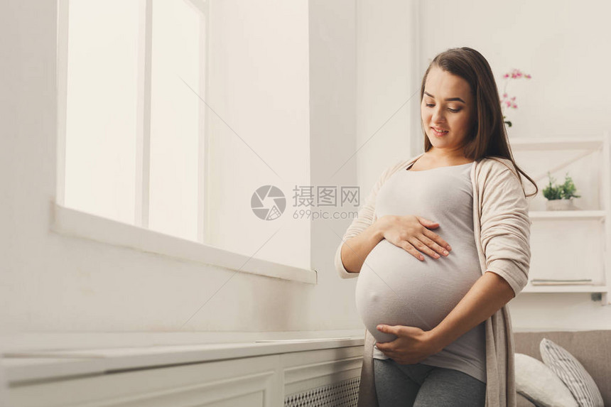 年轻的期待女士感觉她的婴儿推图片