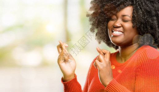 美丽的非洲女人用交叉手指向户外寻图片