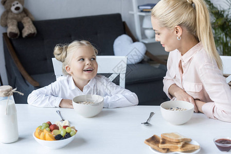 快乐的母亲和女儿一起吃早餐在家里图片