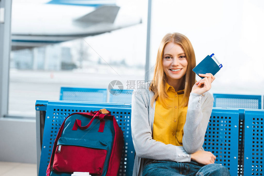 带着护照和机票在机场靠近背包的笑图片