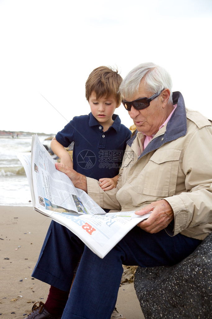 快乐的孩子和祖父在海滩上玩得很开心图片
