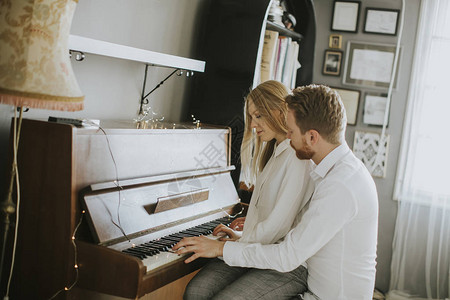 在家里的房间里弹钢琴的恩爱夫妻图片