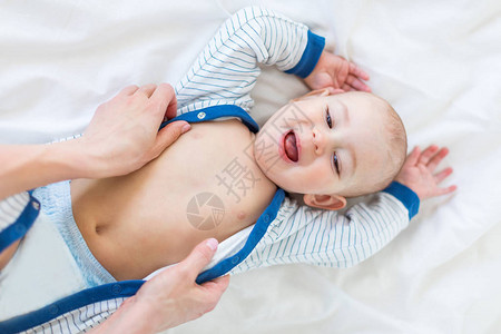 父母与躺在床上一岁婴儿概念的可爱新生婴儿一起玩耍的幼稚婴图片