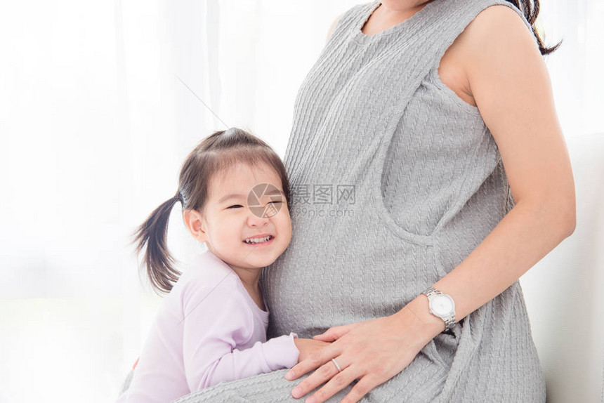 亚洲小女孩从她怀孕的母亲的图片