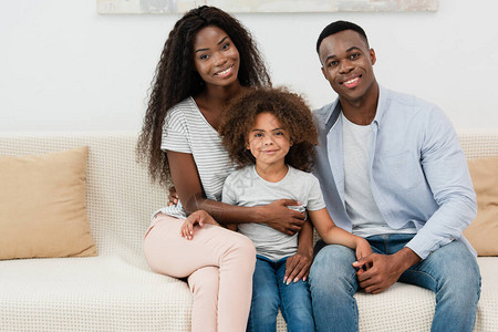 非裔美国人家庭在客厅看相机坐在沙图片