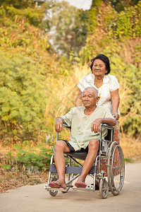 亚洲高级女在轮椅上推着她的残疾肩带图片