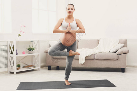 愉快的孕妇在树姿势训练瑜伽母积极怀孕幸福训图片