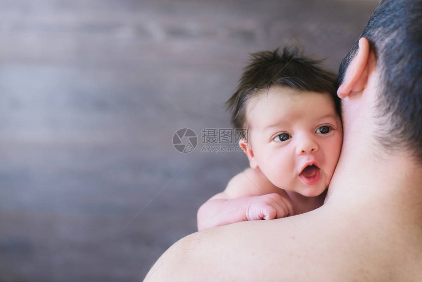 刚出生的婴儿和爸父亲带着婴儿看着他的肩膀快乐的孩子和他图片
