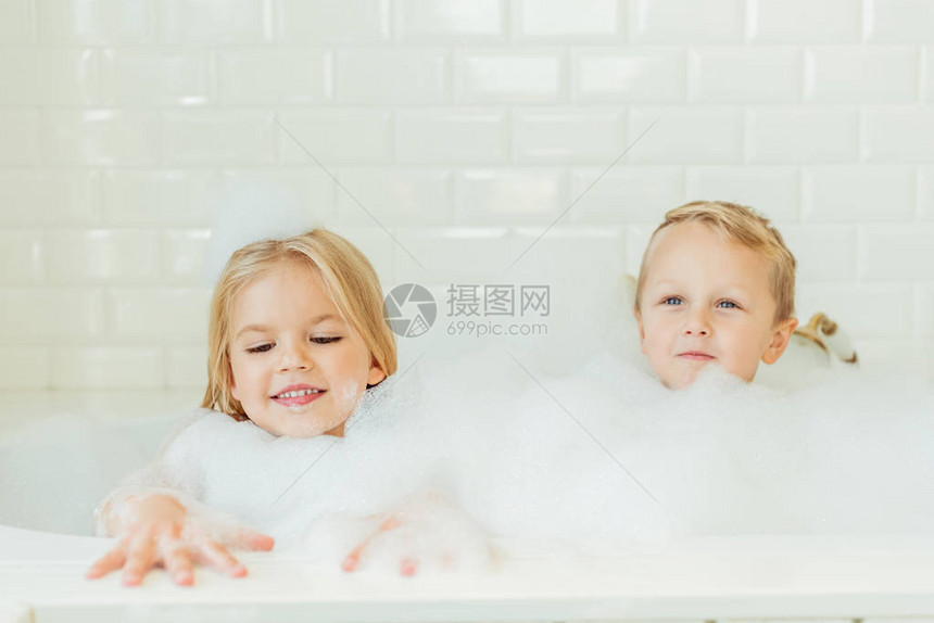 美丽的幸福的兄妹在浴缸里一图片