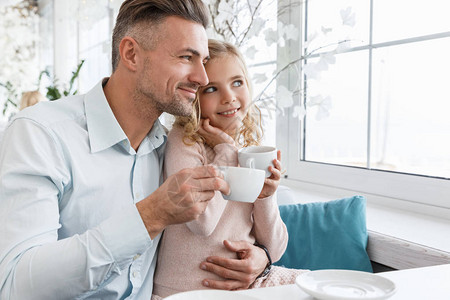 年轻父亲和女儿在咖图片