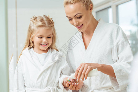 在浴袍中微笑的母亲和女儿图片