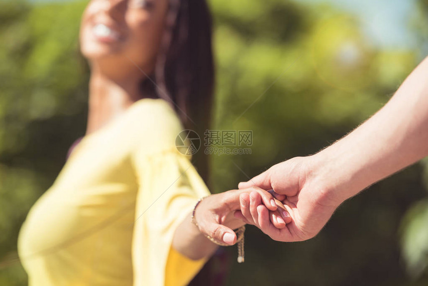 年轻幸福情侣手牵的近景图片