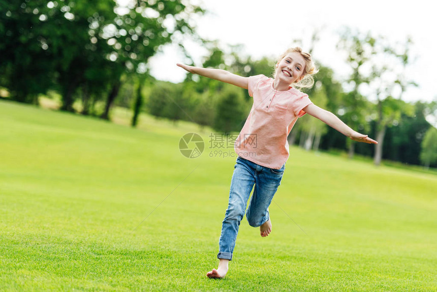 可爱快乐的小女孩张开双臂在公园图片