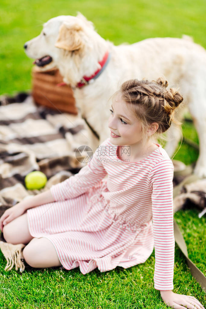 可爱笑的小女孩在野餐时与狗一起休息图片