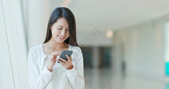 在购物中心使用手机的女人图片