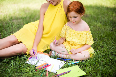 父母素材填色黄裙子中美丽的母亲和女儿的青草镜头背景