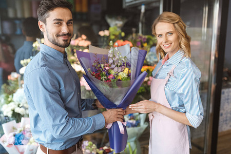 花店和买手拿着美丽的花束在花店里图片