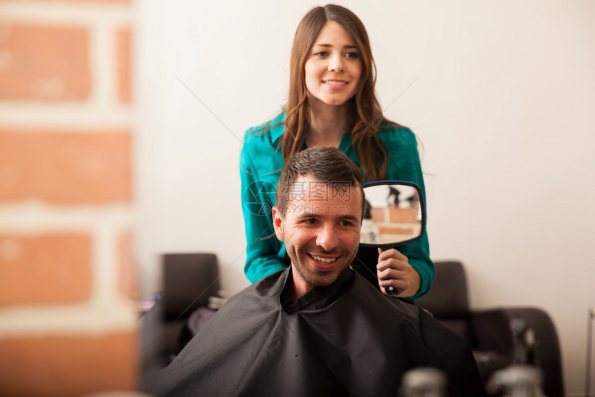 开心的顾客在理发店理发后在镜子里看着图片
