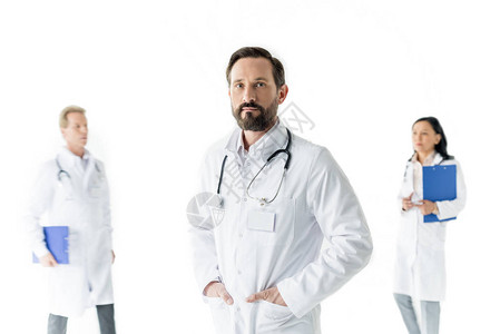 男专业男专业医生在看镜头和同事站在后面图片