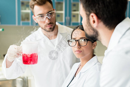 专业的年轻化学家团队戴着眼镜和实验图片