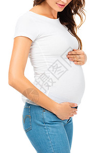 美丽的孕妇触摸腹部时两只手被白图片