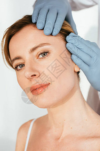 乳胶手套检查有吸引力的白病人毛发时皮肤科医图片