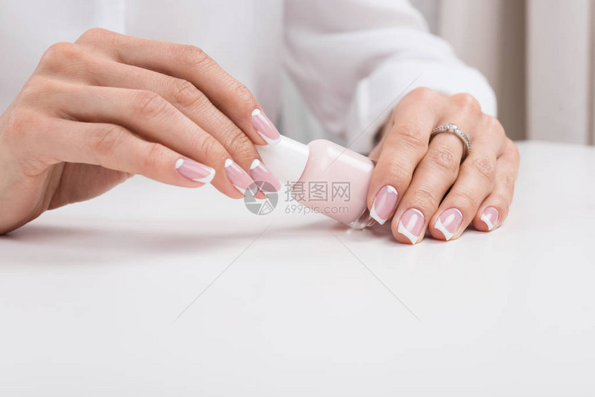 女在修指甲时拿着指甲油图片