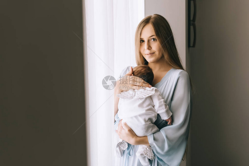 母亲在窗帘前有选择地聚焦带小婴图片
