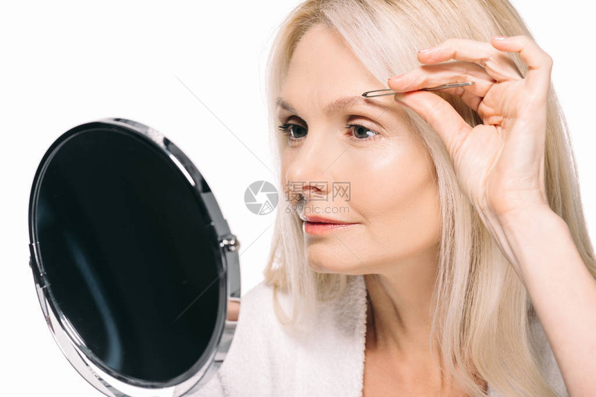 成年女看镜子做眉更正孤立在图片
