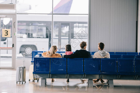 坐在机场候机时等待飞行的年轻人图片