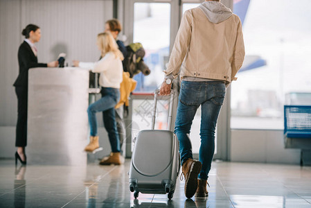 携带手提箱的男子在机场报图片