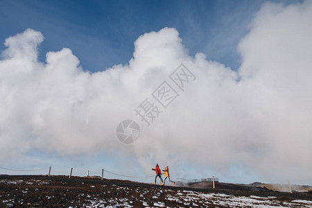 年轻夫妇与来自后面地热泉雷克雅内斯甘努弗温泉冰原的图片