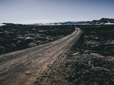 冰岛的公路和黑色岩石和山脉的风景图片