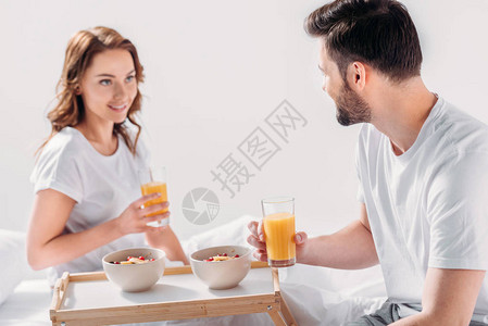 早上在床上吃早餐的年轻夫妇一图片