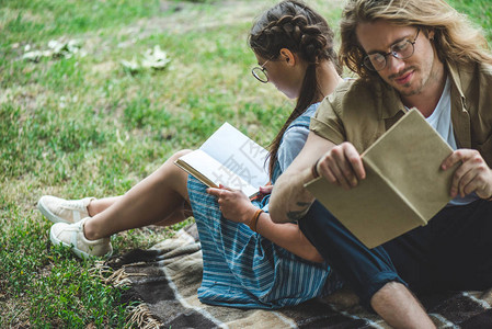 快乐的年轻夫妇在公园读书图片
