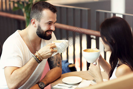 图片显示浪漫情侣在咖啡馆约会图片