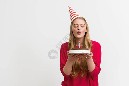 在生日蛋糕上吹蜡烛孤立在白色的白图片