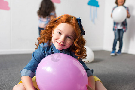 可爱的红发小姑娘在生日派对上拿着气球图片