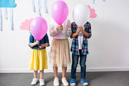 可爱的小可爱孩子拿着气球站在生日派对上图片