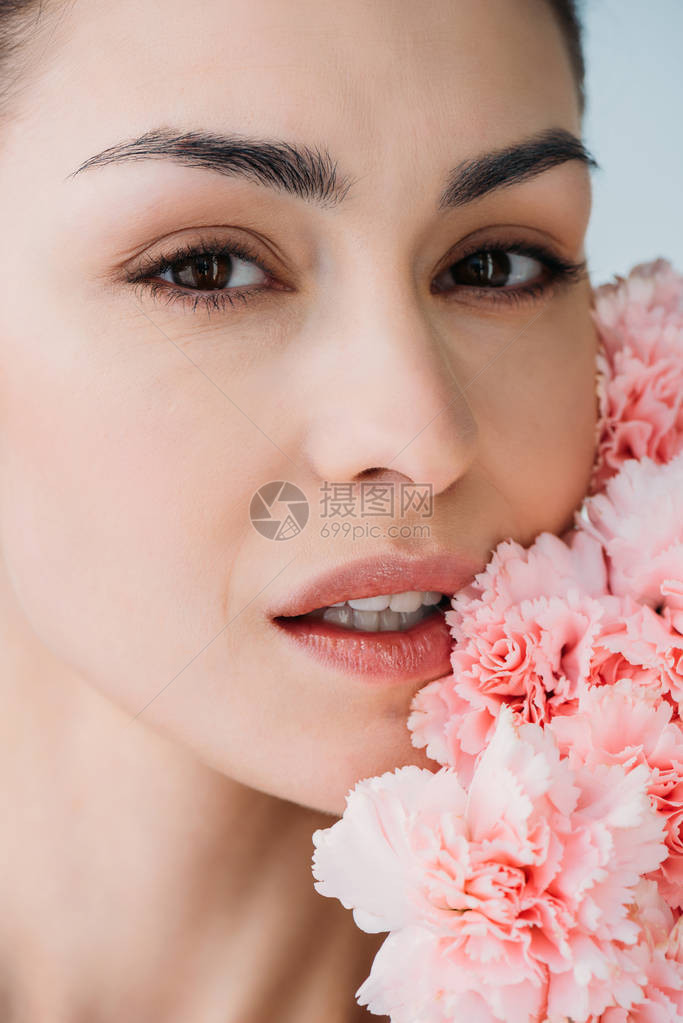 没有化妆的感女人的肖像镜头在她脸上一束鲜花贴在她的脸上图片