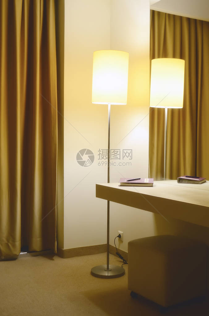 旅馆房间角落的地板灯镜子和装有笔记本图片