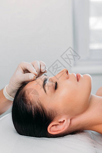 美容学家在温泉沙龙的针刺治疗中部分地将针头放图片